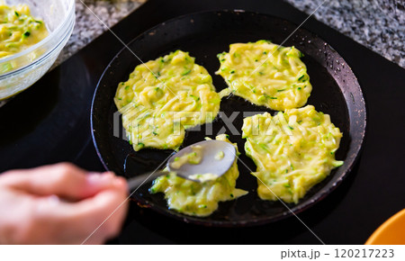 Cooking delicious zucchini pancakes in frying pan Cooking delicious zucchini pancakes in frying pan 120217223