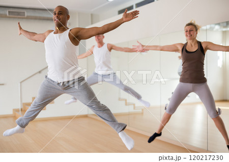 Group of active dancers in jump in dance hall 120217230