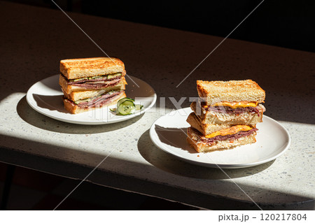 Portions of sandwich with pickles on the table Portions of sandwich with pickles on the table 120217804