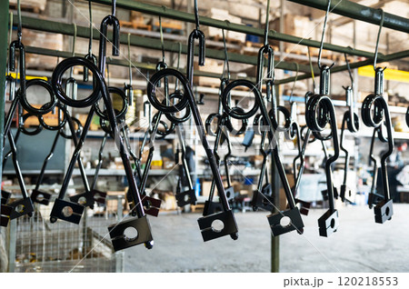 Industrial metal parts hanging in a factory Industrial metal parts hanging in a factory 120218553