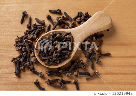 Whole cloves spice in a spoon over wooden background. 120219948
