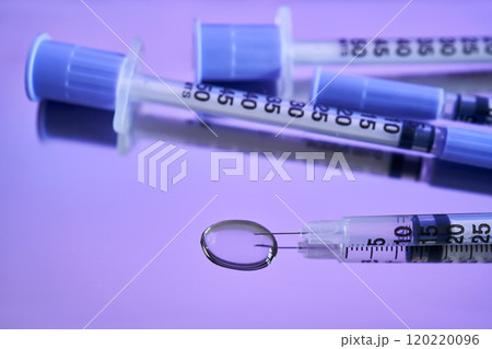Injection syringes on a medical tray in bright violet color. Injection syringes on a medical tray in bright violet color. 120220096
