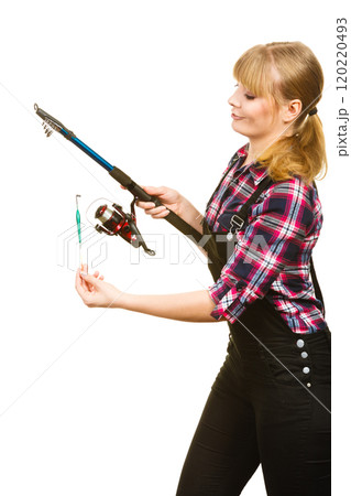 Similing woman wearing check shirt holding fishing rod Similing woman wearing check shirt holding fishing rod 120220493