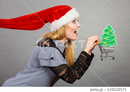 Santa woman holding shopping cart with christmas gifts 120220571