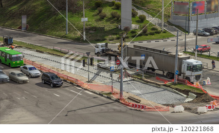 Loader crane for loading and unloading sleepers from truck which stands on a road construction site aerial timelapse Loader crane for loading and unloading sleepers from truck which stands on a road construction site aerial timelapse 120221868