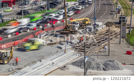 Loader crane for loading and unloading sleepers from truck which stands on a road construction site aerial timelapse 120221872