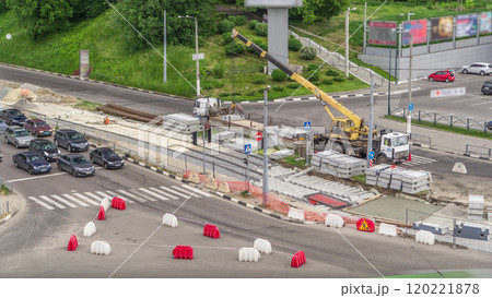 Loader crane for loading and unloading concrete plates from truck which stands on a road construction site aerial timelapse Loader crane for loading and unloading concrete plates from truck which stands on a road construction site aerial timelapse 120221878