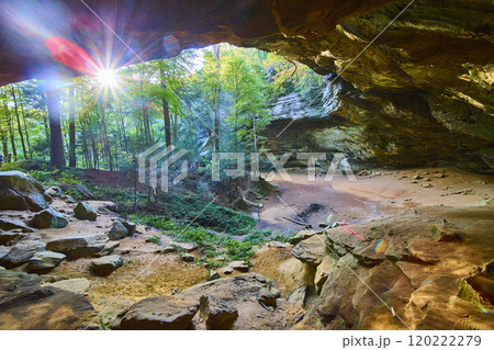 Cave to Forest View with Sunlit Greenery and Figures in Distance 120222279