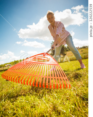 Unusual angle of woman raking leaves Unusual angle of woman raking leaves 120222539