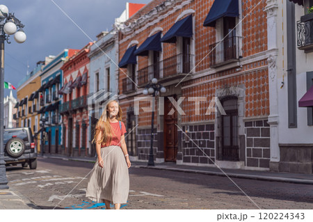 Female tourist walking through the colorful colonial streets of Puebla, Mexico. Travel, cultural exploration, and vibrant architecture concept Female tourist walking through the colorful colonial streets of Puebla, Mexico. Travel, cultural exploration, and vibrant architecture concept 120224343
