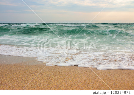 seascape in the morning. summer vacation. stormy weather. green waves crashing on sandy beach. cloudy sky. travel background seascape in the morning. summer vacation. stormy weather. green waves crashing on sandy beach. cloudy sky. travel background 120224972