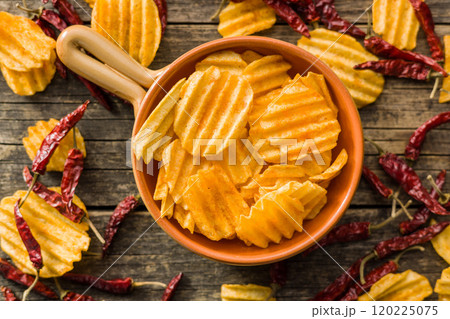 Crispy potato chips in bowl on wooden table. Top view. Crispy potato chips in bowl on wooden table. Top view. 120225075