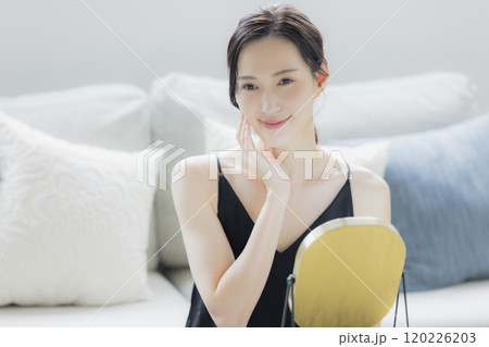 リビングでスキンケアをする女性 リビングでスキンケアをする女性 120226203