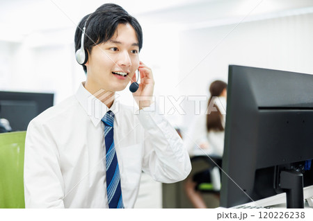 ヘッドセットをつけて電話応対するビジネスマン 120226238