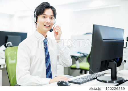 ヘッドセットをつけて電話応対するビジネスマン 120226289