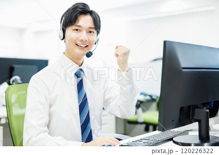 ヘッドセットをつけて電話応対するビジネスマン ヘッドセットをつけて電話応対するビジネスマン 120226322