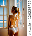 窓際で陽を浴びる女性 120226729