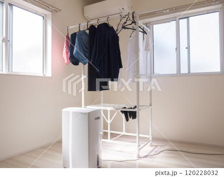 部屋に設置された物干しスタンドと稼働中の除湿機　梅雨時期の部屋干し　 120228032