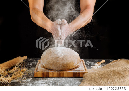 Baker clapping hands with flour over a rustic bread loaf, celebrating the art of homemade baking Baker clapping hands with flour over a rustic bread loaf, celebrating the art of homemade baking 120228828