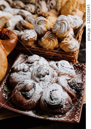Traditional sweet buns with powdered sugar on a decorative plate, perfect for dessert lovers 120228845