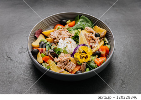 Gourmet salad bowl with tuna, poached egg, colorful vegetables, and edible flower garnish Gourmet salad bowl with tuna, poached egg, colorful vegetables, and edible flower garnish 120228846