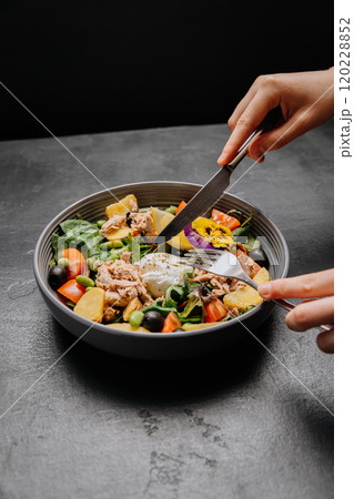 Healthy tuna salad with poached egg, fresh veggies, and edible flower, colorful and nutritious meal 120228852