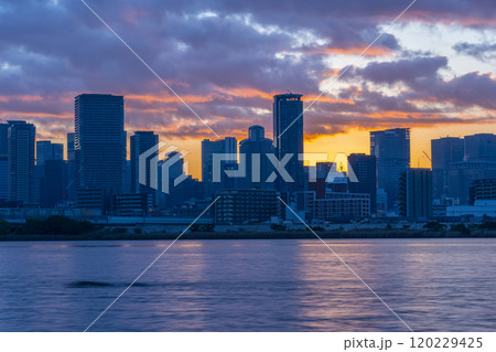 淀川を挟んで見る大阪梅田の高層ビル群と日の出 120229425