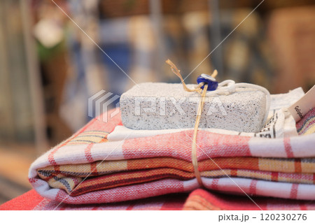 Beautifully Stacked Textiles Have Been Enhanced by a Decorative and Stylish Stone Weight 120230276