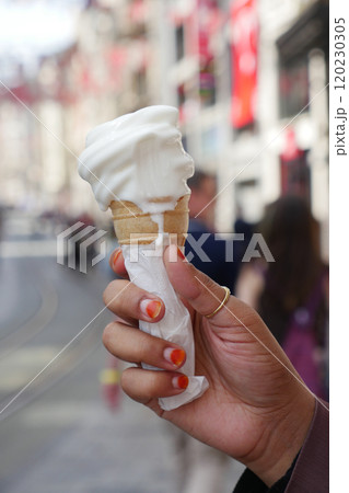 Holding a MouthWatering and Delicious Ice Cream Cone While Strolling Along a Sunny City Street 120230305