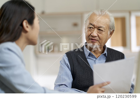asian old man appears to be unconvinced while listening to a salesperson 120230599