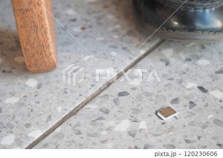 a phone sim card dropped on a tiles floor. lost sim card concept a phone sim card dropped on a tiles floor. lost sim card concept 120230606