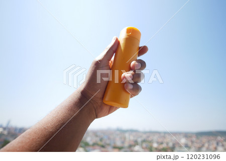 Close up of person hand using sunscreen cream outdoor  120231096