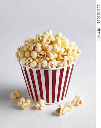 A delicious bowl of popcorn in a classic red and white striped container. 120231496