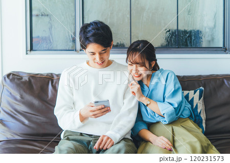 一緒にスマホを見る若い夫婦(カップル) 一緒にスマホを見る若い夫婦(カップル) 120231573