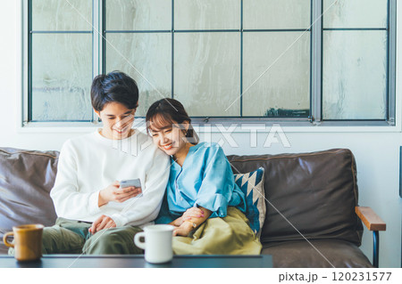 一緒にスマホを見る若い夫婦(カップル) 一緒にスマホを見る若い夫婦(カップル) 120231577