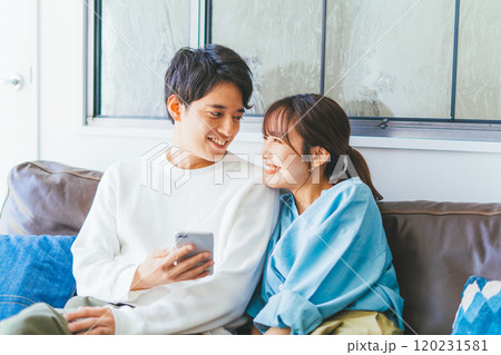 一緒にスマホを見る若い夫婦(カップル) 一緒にスマホを見る若い夫婦(カップル) 120231581
