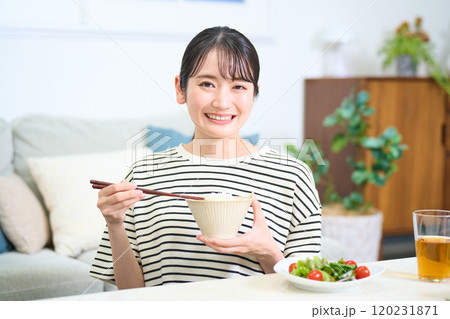 お米を食べる若い女性 120231871