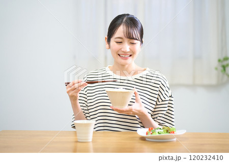 お米を食べる若い女性 お米を食べる若い女性 120232410