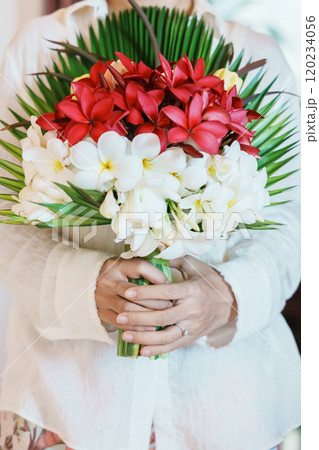 Woman hand wearing a diamond ring and holding flower bouquet. Idea for marriage proposal, romantic surprise, wedding, engagement and valentines day concept Woman hand wearing a diamond ring and holding flower bouquet. Idea for marriage proposal, romantic surprise, wedding, engagement and valentines day concept 120234056