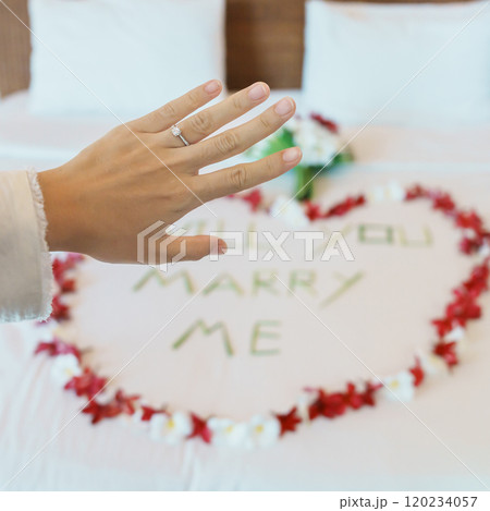 Woman hand wearing a diamond ring after say YES with message WILL YOU MARRY ME made of flower petals with bouquet on bed. Idea for marriage proposal, romantic surprise, wedding and engagement concept Woman hand wearing a diamond ring after say YES with message WILL YOU MARRY ME made of flower petals with bouquet on bed. Idea for marriage proposal, romantic surprise, wedding and engagement concept 120234057