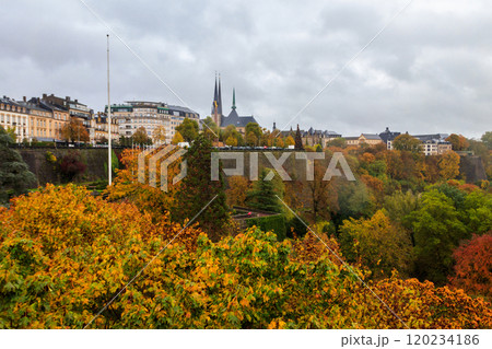 View of Luxembourg city with iconic Gelle Fra (Monument of Remembrance), Notre-Dame cathedral and multicolored autumn  trees 120234186