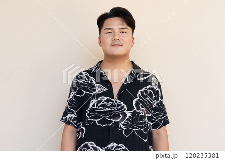 Portrait of Handsome Young Asian Man Against Plain Background 120235381