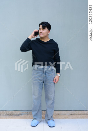 Full Length Portrait of Handsome Young Asian Man Against Plain Background Outdoors 120235485