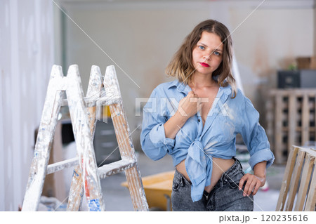 Young seductive woman posing in apartment during repair works 120235616