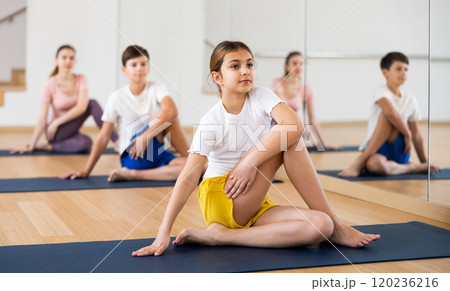 Girl doing lord of the fishes pose in gym Girl doing lord of the fishes pose in gym 120236216
