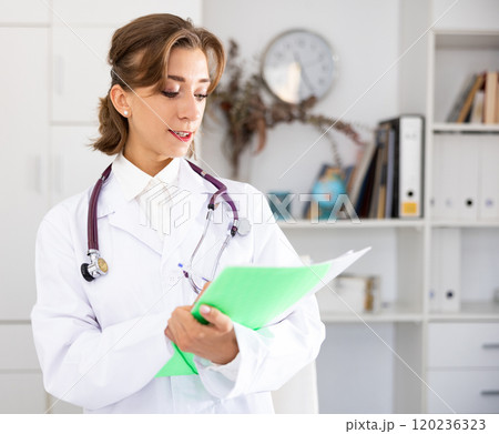 Woman doctor wear white medical uniform and stethoscope with folder of documents 120236323