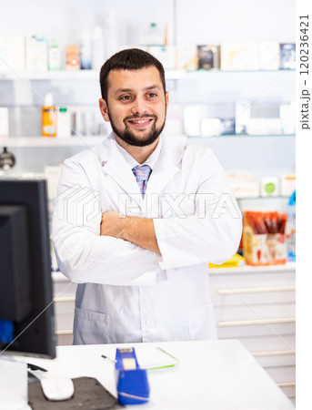 Portrait of male pharmacist working at the cash register in pharmacy 120236421