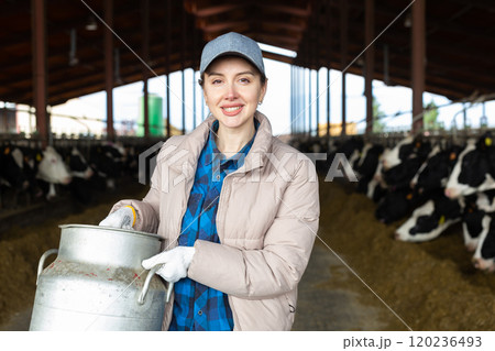 Female farmer standing with big milk can 120236493