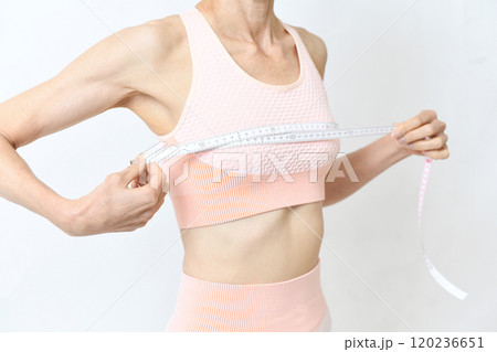 胸にメジャー（巻尺）を巻く女性のイメージ 120236651