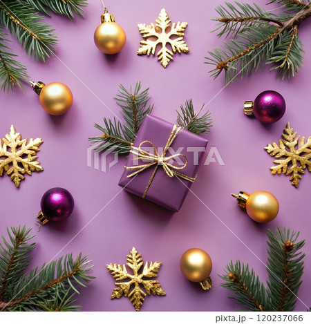 Christmas gift with red ribbon surrounded by holiday decorations and branches on purple background. 120237066